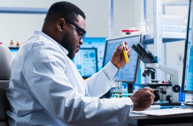 Profesyonel Afro-Amerikan bilim adamı modern bir bilimsel araştırma laboratuvarında aşı üzerinde çalışıyor. Genetik mühendisliği işyeri. Gelecekteki teknoloji ve bilim.