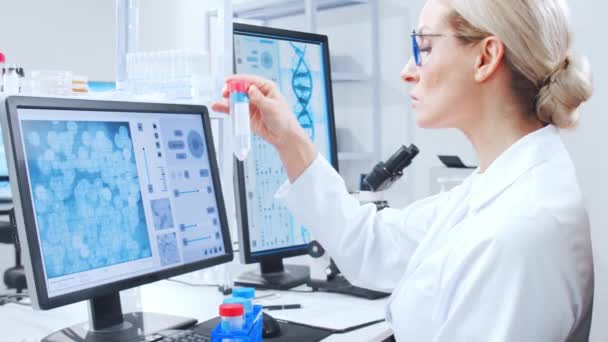 Profesyonel bilim adamları modern bir bilimsel araştırma laboratuvarında bir aşı üzerinde çalışıyorlar. Genetik mühendisliği işyeri. Gelecekteki teknoloji ve bilim. — Stok video