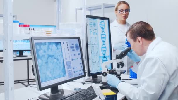 Ein professionelles Wissenschaftlerteam arbeitet in einem modernen wissenschaftlichen Forschungslabor an einem Impfstoff. Gentechniker-Arbeitsplatz. Technologie und Wissenschaft der Zukunft. — Stockvideo