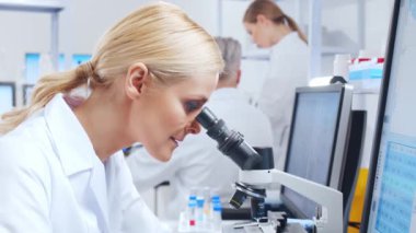 Profesyonel bilim adamları modern bir bilimsel araştırma laboratuvarında bir aşı üzerinde çalışıyorlar. Genetik mühendisliği işyeri. Gelecekteki teknoloji ve bilim.