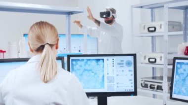 Genetik mühendisleri Sanal Gerçeklik teknolojisini kullanıyorlar. Profesyonel bilim adamları modern bir bilimsel araştırma laboratuvarında bir aşı üzerinde çalışıyorlar. Geleceğin bilimi.