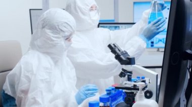 Profesyonel bilim adamları modern bir bilimsel araştırma laboratuvarında bir aşı üzerinde çalışıyorlar. Genetik mühendisliği işyeri. Gelecekteki teknoloji ve bilim.