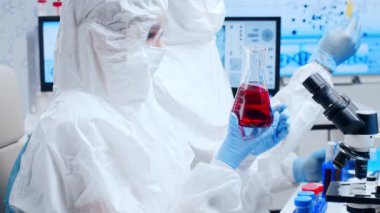 Profesyonel bilim adamları modern bir bilimsel araştırma laboratuvarında bir aşı üzerinde çalışıyorlar. Genetik mühendisliği işyeri. Gelecekteki teknoloji ve bilim.