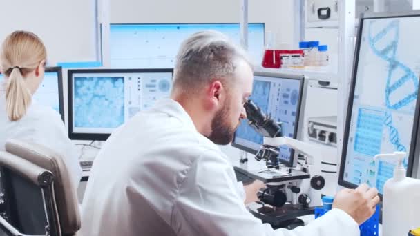 Professioneel team van wetenschappers werkt aan een vaccin in een modern wetenschappelijk onderzoekslaboratorium. Genetische ingenieur werkplek. Toekomstige technologie en wetenschap. — Stockvideo