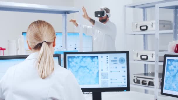 Genetische ingenieurs gebruiken Virtual Reality technologie. Professioneel team van wetenschappers werkt aan een vaccin in een modern wetenschappelijk onderzoekslaboratorium. Wetenschap van de toekomst. — Stockvideo