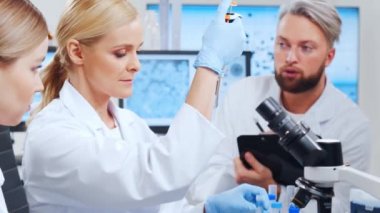 Profesyonel bilim adamları modern bir bilimsel araştırma laboratuvarında bir aşı üzerinde çalışıyorlar. Genetik mühendisliği işyeri. Gelecekteki teknoloji ve bilim.