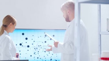 Profesyonel bilim adamları modern bir bilimsel araştırma laboratuvarında bir aşı üzerinde çalışıyorlar. Genetik mühendisliği işyeri. Gelecekteki teknoloji ve bilim.