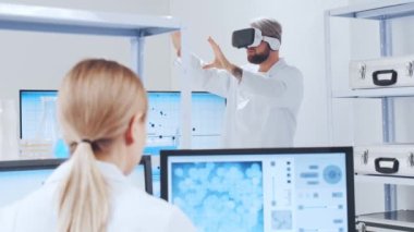 Genetik mühendisleri Sanal Gerçeklik teknolojisini kullanıyorlar. Profesyonel bilim adamları modern bir bilimsel araştırma laboratuvarında bir aşı üzerinde çalışıyorlar. Geleceğin bilimi.