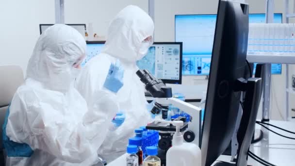 El equipo profesional de científicos está trabajando en una vacuna en un moderno laboratorio de investigación científica. Trabajo de ingeniero genético. Tecnología y ciencia del futuro. — Vídeos de Stock