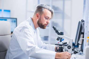 Profesyonel bilim adamı modern bir bilimsel araştırma laboratuvarında aşı üzerinde çalışıyor. Genetik mühendisliği işyeri. Gelecekteki teknoloji ve bilim.