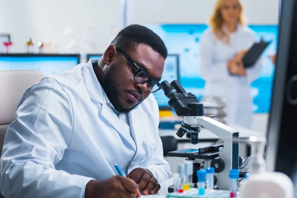 Profesyonel bilim adamları modern bir bilimsel araştırma laboratuvarında bir aşı üzerinde çalışıyorlar. Genetik mühendisliği işyeri. Gelecekteki teknoloji ve bilim.