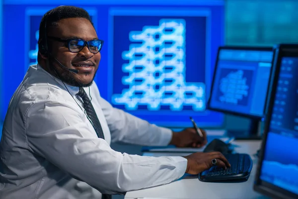 Afro-Amerikaanse makelaar werkt in het kantoor met behulp van werkstation en analyse technologie. Werkplaats van de professionele handelaar. Mondiale financiële markten, bedrijfs-, valutawisselings- en bankconcepten. — Stockfoto