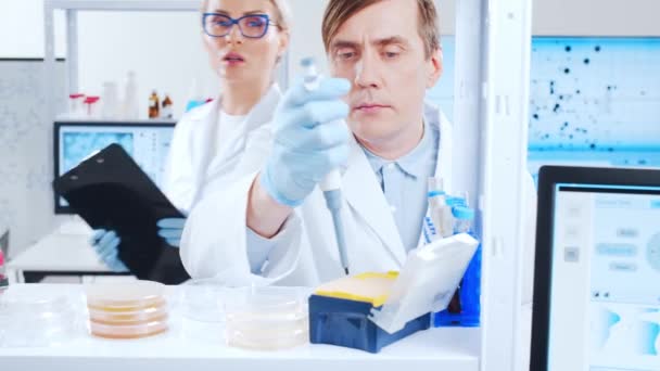 Profesjonalny zespół naukowców pracuje nad szczepionką w nowoczesnym laboratorium naukowym. Miejsce pracy inżyniera genetycznego. Przyszłe technologie i nauka. — Wideo stockowe