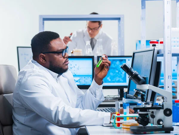Cientista afro-americano profissional está trabalhando em uma vacina em um laboratório de pesquisa científica moderna. Engenheiro genético no trabalho. Tecnologia e ciência futuras. — Fotografia de Stock