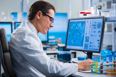 Profesyonel bilim adamı modern bir bilimsel araştırma laboratuvarında aşı üzerinde çalışıyor. Genetik mühendisliği işyeri. Gelecekteki teknoloji ve bilim.