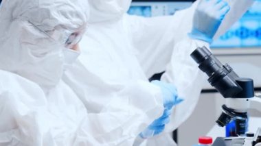 Profesyonel bilim adamları modern bir bilimsel araştırma laboratuvarında bir aşı üzerinde çalışıyorlar. Genetik mühendisliği işyeri. Gelecekteki teknoloji ve bilim.