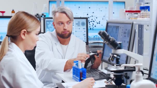 Professioneel team van wetenschappers werkt aan een vaccin in een modern wetenschappelijk onderzoekslaboratorium. Genetische ingenieur werkplek. Toekomstige technologie en wetenschap. — Stockvideo