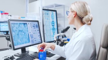 Profesyonel bilim adamları modern bir bilimsel araştırma laboratuvarında bir aşı üzerinde çalışıyorlar. Genetik mühendisliği işyeri. Gelecekteki teknoloji ve bilim.