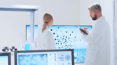 Profesyonel bilim adamları modern bir bilimsel araştırma laboratuvarında bir aşı üzerinde çalışıyorlar. Genetik mühendisliği işyeri. Gelecekteki teknoloji ve bilim.
