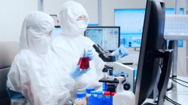 Profesyonel bilim adamları modern bir bilimsel araştırma laboratuvarında bir aşı üzerinde çalışıyorlar. Genetik mühendisliği işyeri. Gelecekteki teknoloji ve bilim.