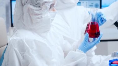Profesyonel bilim adamları modern bir bilimsel araştırma laboratuvarında bir aşı üzerinde çalışıyorlar. Genetik mühendisliği işyeri. Gelecekteki teknoloji ve bilim.