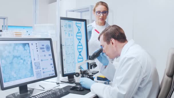 一个由专业科学家组成的小组正在一个现代科学研究实验室里研究一种疫苗。基因工程工作场所。未来的技术和科学. — 图库视频影像