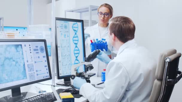 Profesyonel bilim adamları modern bir bilimsel araştırma laboratuvarında bir aşı üzerinde çalışıyorlar. Genetik mühendisliği işyeri. Gelecekteki teknoloji ve bilim. — Stok video