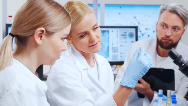 A tudósok profi csapata egy vakcinán dolgozik egy modern tudományos kutató laboratóriumban. Genetikai mérnöki munkahely. Jövőbeli technológia és tudomány. — Stock videók