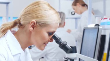 Profesyonel bilim adamları modern bir bilimsel araştırma laboratuvarında bir aşı üzerinde çalışıyorlar. Genetik mühendisliği işyeri. Gelecekteki teknoloji ve bilim.