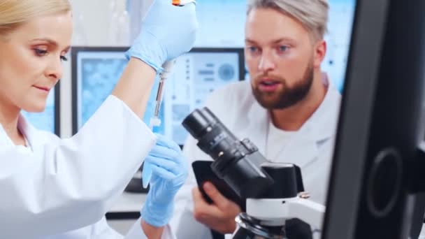 전문적 인 과학자 팀이 현대 과학 연구 실험실에서 백신을 개발하고 있다. 유전 공학자의 직장. 미래의 기술과 과학. — 비디오
