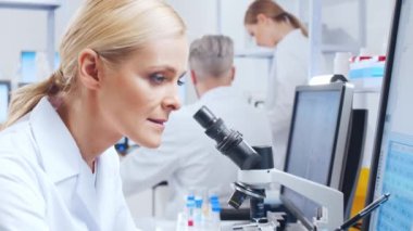 Profesyonel bilim adamları modern bir bilimsel araştırma laboratuvarında bir aşı üzerinde çalışıyorlar. Genetik mühendisliği işyeri. Gelecekteki teknoloji ve bilim.