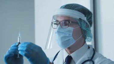 Makk ve koruyucu vizörlü genç bir tıp doktorunun stüdyo portresi. Bulaşıcı hastalıklar uzmanı. Covid-19 salgın konsepti.