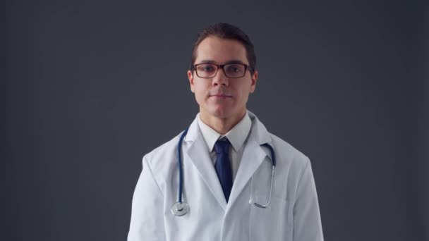 Studioportrett av en ung profesjonell lege som arbeider med usynlige digitale bildegrensesnitt over grå bakgrunn – stockvideo