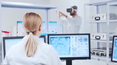 Genetik mühendisleri Sanal Gerçeklik teknolojisini kullanıyorlar. Profesyonel bilim adamları modern bir bilimsel araştırma laboratuvarında bir aşı üzerinde çalışıyorlar. Geleceğin bilimi.