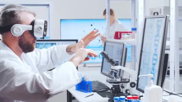 Ein professionelles Wissenschaftlerteam arbeitet in einem modernen wissenschaftlichen Forschungslabor an einem Impfstoff. Gentechniker-Arbeitsplatz. Technologie und Wissenschaft der Zukunft. — Stockvideo