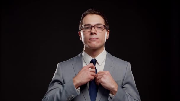 Retrato de estúdio de empresário bem sucedido e inteligente em terno e gravata. Homem em desgaste formal sobre fundo preto. — Vídeo de Stock