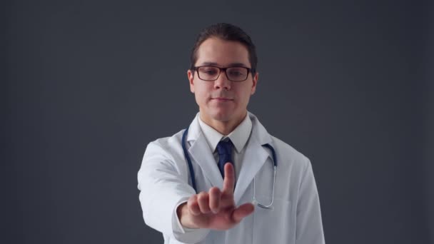 Studioportrett av en ung profesjonell lege som arbeider med usynlige digitale bildegrensesnitt over grå bakgrunn – stockvideo