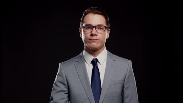 Retrato de estudio de empresario exitoso e inteligente en traje y corbata. Hombre en desgaste formal sobre fondo negro. — Vídeo de stock