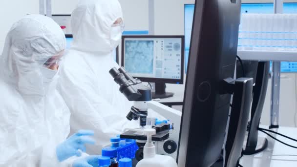 A tudósok profi csapata egy vakcinán dolgozik egy modern tudományos kutató laboratóriumban. Genetikai mérnöki munkahely. Jövőbeli technológia és tudomány. — Stock videók