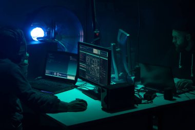 Bilgisayar ve dizüstü bilgisayar kullanarak virüs fidye virüsü kodlayan aranan hackerlar. Siber saldırı, sistem kırma ve kötü amaçlı yazılım kavramı.