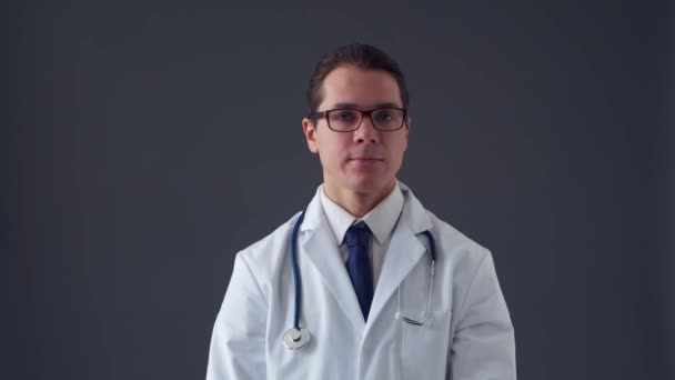 Retrato de estúdio de jovem médico profissional sobre fundo cinza — Vídeo de Stock