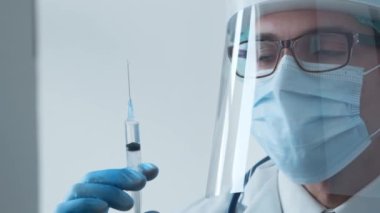 Makk ve koruyucu vizörlü genç bir tıp doktorunun stüdyo portresi. Bulaşıcı hastalıklar uzmanı. Covid-19 salgın konsepti.