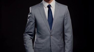 Takım elbiseli ve kravatlı başarılı ve zeki iş adamının stüdyo portresi. Siyah arka planda resmi giyinen adam.