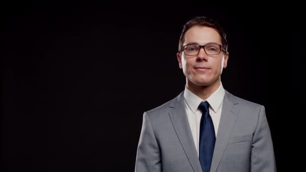 Stúdió portré sikeres és okos üzletemberről öltönyben és nyakkendőben. Férfi a formális kopás felett fekete háttér. — Stock videók