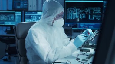 Mikro elektronik mühendisi, bilgisayar sistemleri ve mikroişlemciler üzerine modern bir bilim laboratuvarında çalışıyor. Elektronik fabrika işçisi ana kartı test ediyor ve yazılımı kodluyor..