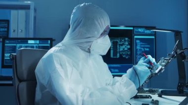 Mikro elektronik mühendisi, bilgisayar sistemleri ve mikroişlemciler üzerine modern bir bilim laboratuvarında çalışıyor. Elektronik fabrika işçisi ana kartı test ediyor ve yazılımı kodluyor..
