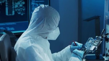 Mikro elektronik mühendisi, bilgisayar sistemleri ve mikroişlemciler üzerine modern bir bilim laboratuvarında çalışıyor. Elektronik fabrika işçisi ana kartı test ediyor ve yazılımı kodluyor..