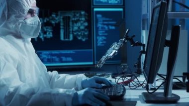 Mikro elektronik mühendisi, bilgisayar sistemleri ve mikroişlemciler üzerine modern bir bilim laboratuvarında çalışıyor. Elektronik fabrika işçisi ana kartı test ediyor ve yazılımı kodluyor..