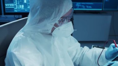 Mikro elektronik mühendisi, bilgisayar sistemleri ve mikroişlemciler üzerine modern bir bilim laboratuvarında çalışıyor. Elektronik fabrika işçisi ana kartı test ediyor ve yazılımı kodluyor..