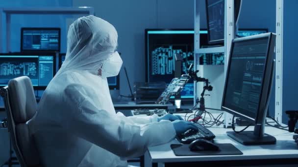 Microelectronics engineer works in a modern scientific laboratory on computing systems and microprocessors. Electronic factory worker is testing the motherboard and coding the firmware. — Stock Video